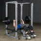 White metal power rack with adjustable safety bars and j-hooks, person performing barbell bench press in garage setting