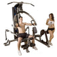 Multi-station home gym with gray and blue frame, featuring chest press, leg press, and cable machine stations, demonstrated b