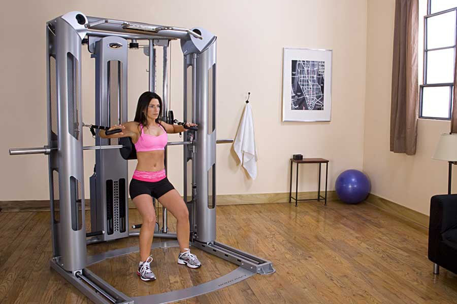 BodyCraft Jones Platinum Smith Cage, silver multi-station home gym with woman using cable arms in gym setting