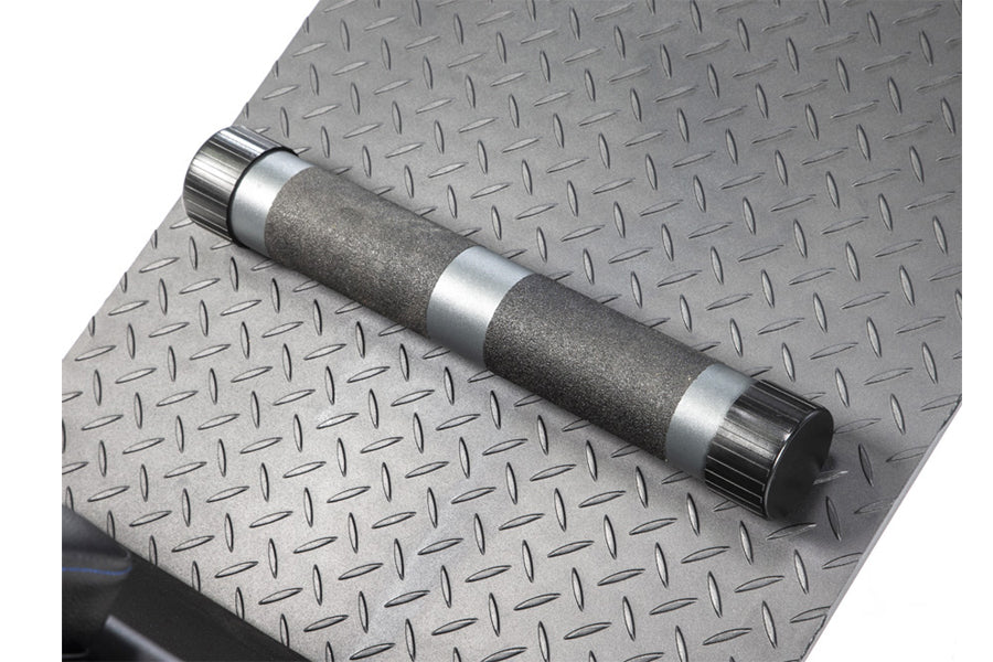 Chrome and gray dumbbell with textured grip on diamond plate gym flooring