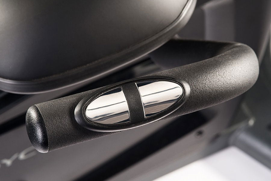 Black textured handle grip with chrome accents on exercise bike, close-up detail view