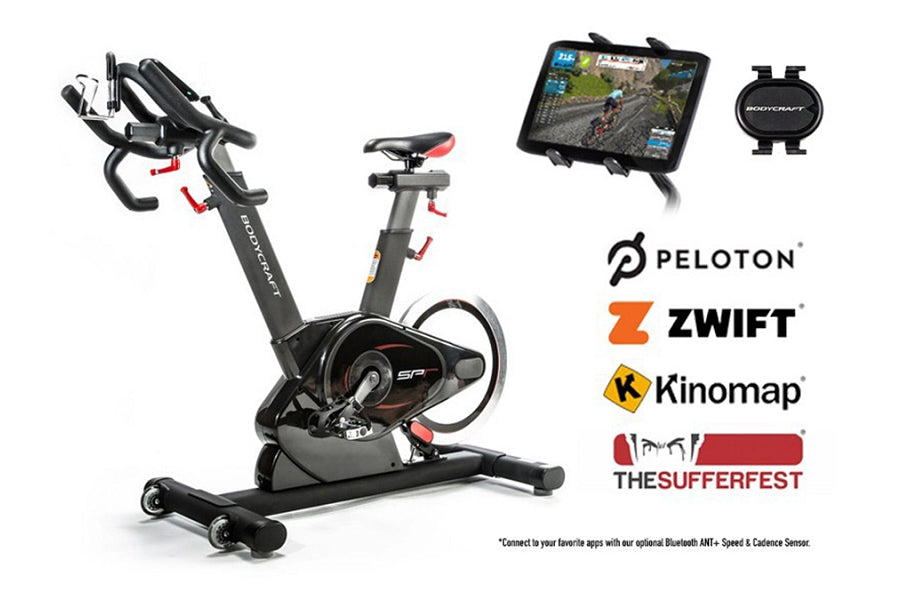 BodyCraft SPR indoor stationary exercise bike in black with red accents, shown with tablet holder, heart rate monitor, and co