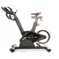 Black and red stationary indoor cycling bike with adjustable handlebars, padded seat, and weighted flywheel on white backgrou