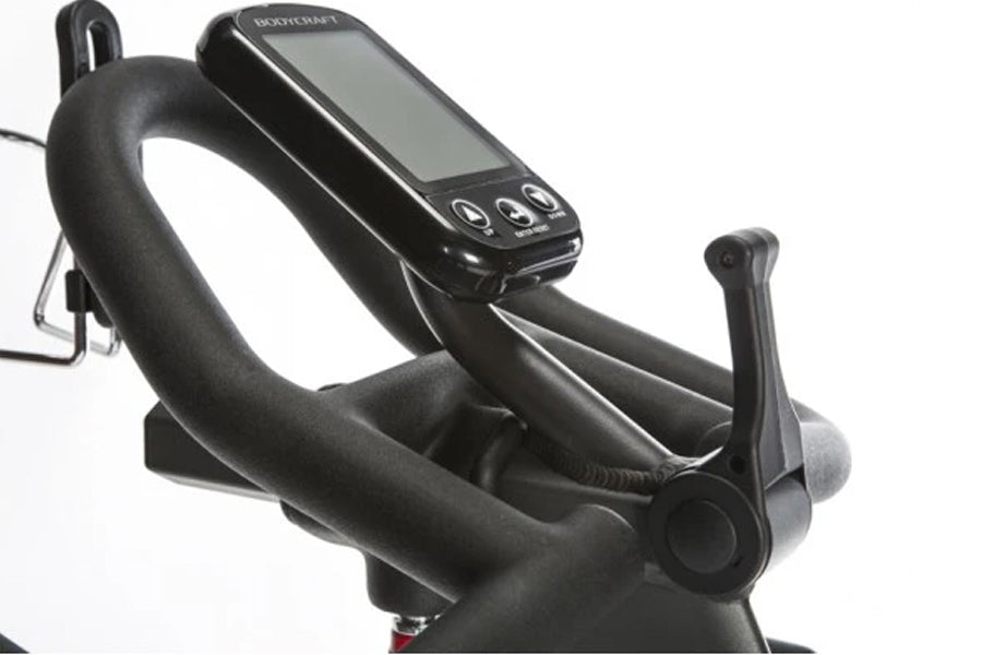 BodyCraft SPR stationary exercise bike with black padded seat and handlebars, digital display console mounted on frame, shown
