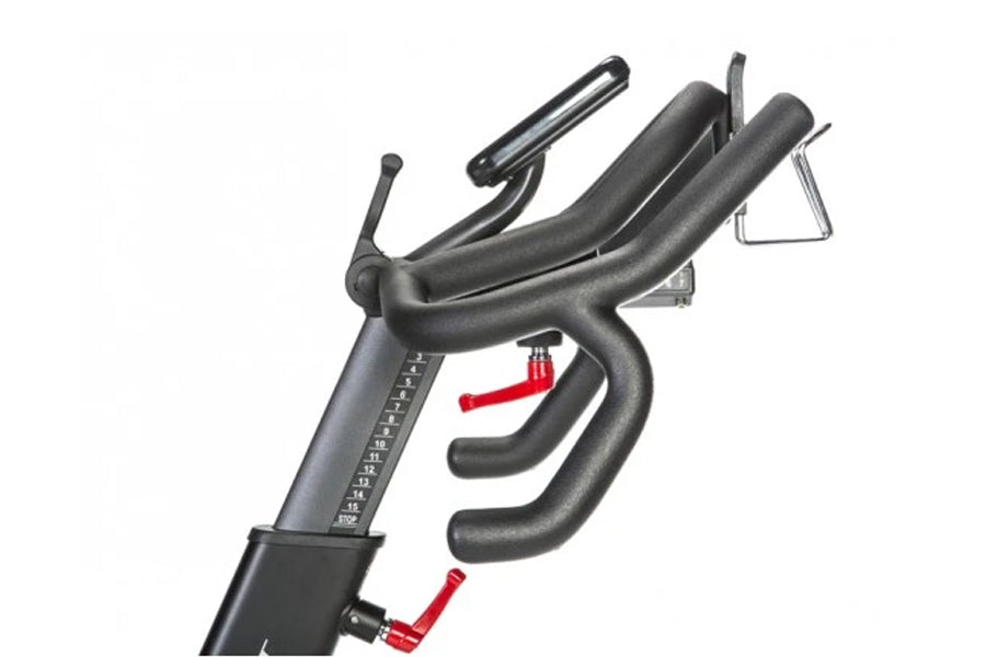 BodyCraft SPR indoor exercise bike with black frame, curved handlebars, padded seat, and red resistance adjustment lever on w