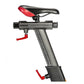 Stationary exercise bike with black and red seat, gray resistance column with measurement markings, and red adjustment handle