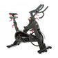 Black indoor training cycle with red accents, dual handles, red seat, and fixed wheelbase on white background