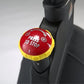 Red and yellow "Press to Stop" brake button mounted on black indoor cycle handlebar