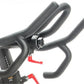 Black stationary indoor cycling bike with padded handlebars and red accent details on white background