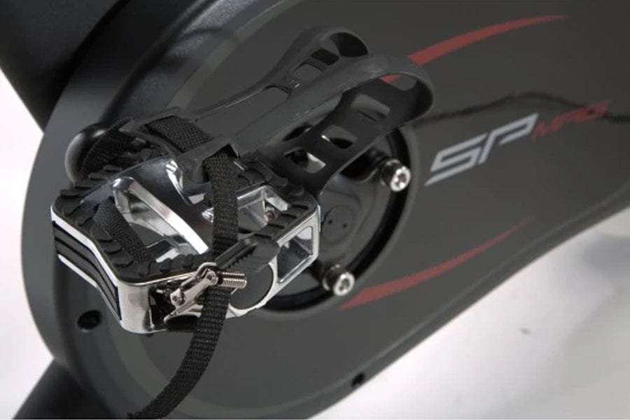 SPT-Mag magnetic pedals with black straps and chrome cage on indoor cycle, close-up detail view