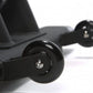 Black indoor training cycle with dual wheels and metal axles on white background