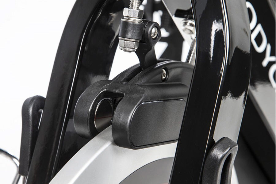 Black and silver stationary bike brake caliper and frame detail on white background