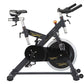 Black and silver stationary indoor exercise bike with large flywheel, padded seat, and handlebar grips on white background