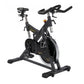 Black and gray stationary indoor training cycle with curved handlebars, padded seat, and large flywheel, on white background