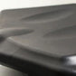 Black rowing machine seat with curved ergonomic design and padded surface, close-up detail view