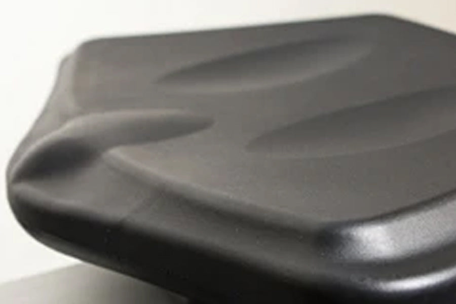 Black rowing machine seat with curved ergonomic design and padded surface, close-up detail view