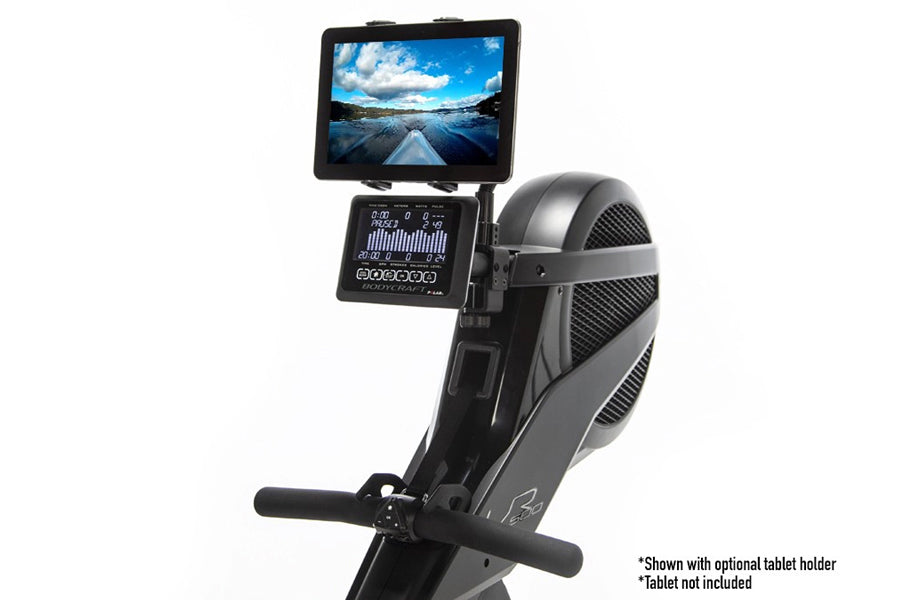Black and gray upright stationary bike with digital console displaying metrics, tablet holder mounted on handlebar showing la