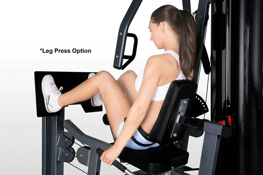 Woman using leg press option on black BodyCraft Xpress Pro home gym machine with touchscreen display