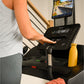 Person in light gray shirt using black Bowflex T6 treadmill console with screen displaying workout data, yellow water bottle 