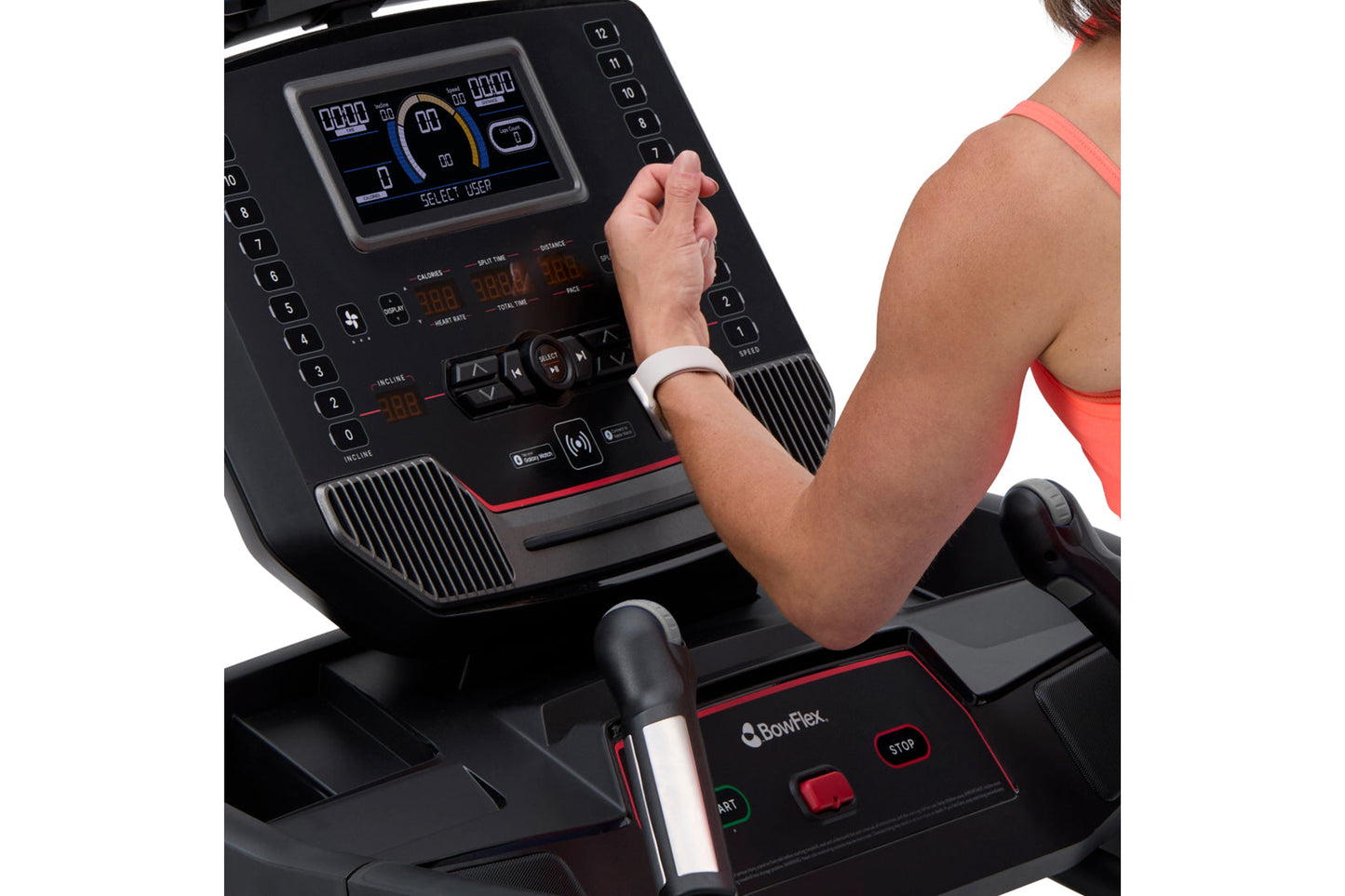 Person wearing coral sports bra using BowFlex T9 treadmill with digital display console and red accent trim, shown from side 
