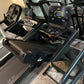 Black folding treadmill with digital display showing speed and incline, dual handholds, and black frame on concrete surface