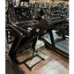 Black folding treadmill with digital display console and yellow accents, shown in gym setting