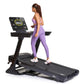 Woman wearing purple sports bra and leggings running on black folding treadmill with digital display screen