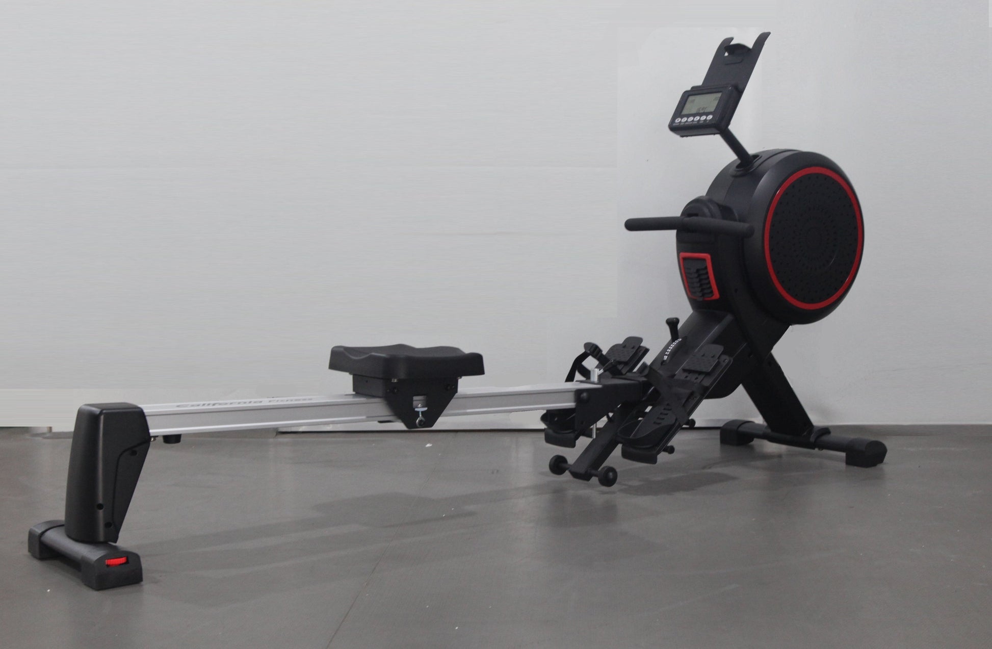 Black California Fitness AR5 rowing machine with red accents, digital display, and foot pedals on gray background