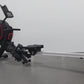Black and red rowing machine with digital display monitor, foot pedals, and sliding seat on metal rail, on gray background