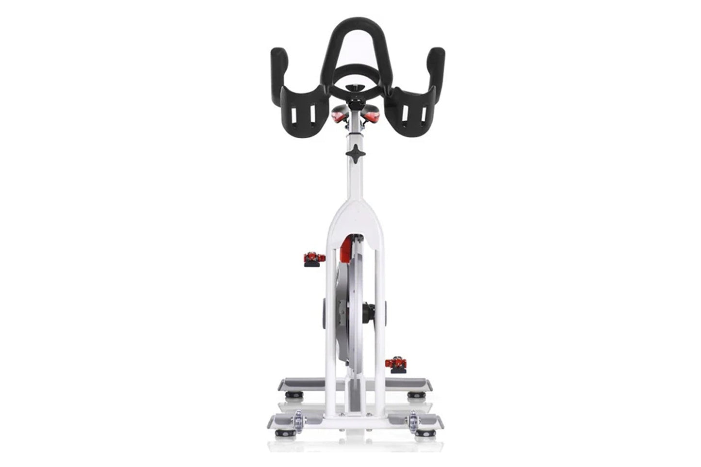 White and black stationary indoor cycling bike with red accents, curved handlebars, and digital display, viewed from front on