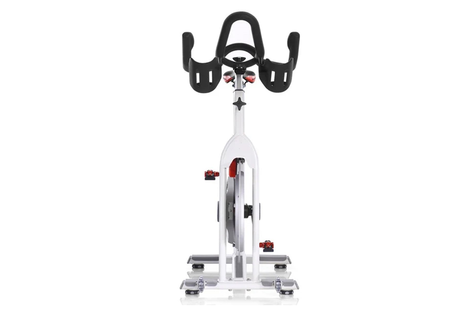 White and black stationary indoor cycling bike with red accents, curved handlebars, and digital display, viewed from front on