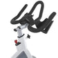White and black stationary indoor exercise bike with curved black handlebars and red resistance dial on white background