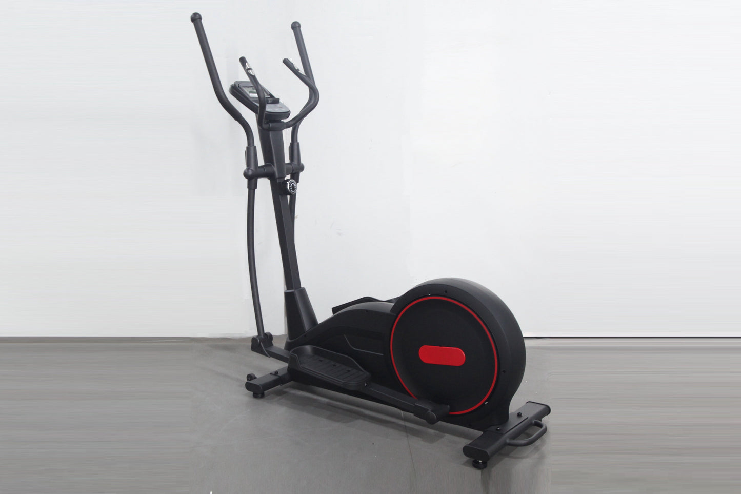 Black elliptical cross-trainer with red accents and curved handles, displayed on gray floor against white background