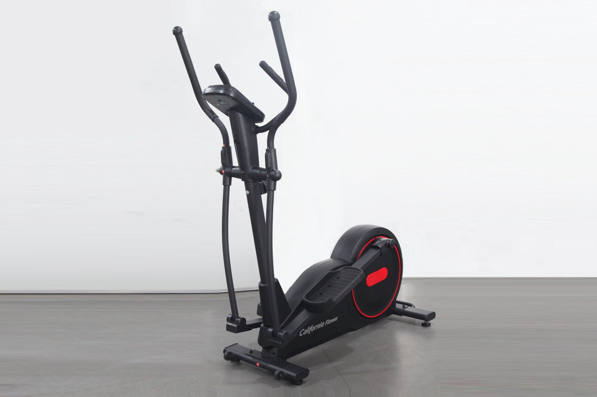Black and red elliptical cross-trainer with dual handles and foot pedals on gray floor, white background