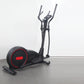 Black and red elliptical cross-trainer machine with curved handles and illuminated wheel accent, on gray floor