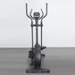 Black elliptical cross-trainer with dual handles, digital display console, and large flywheel, shown on gray floor against wh