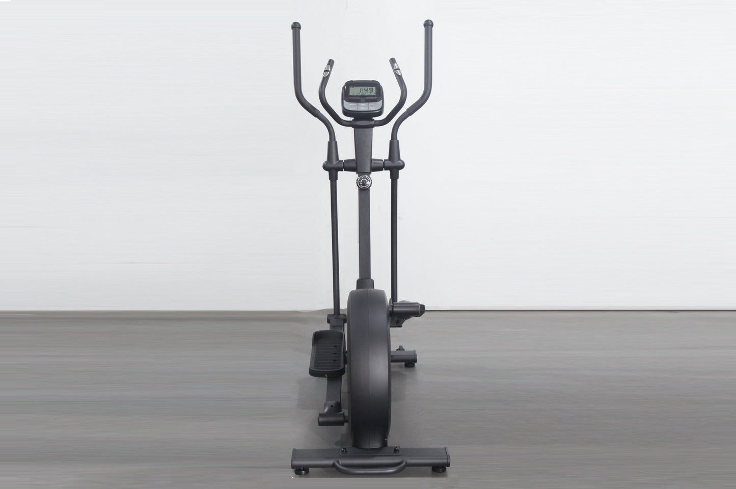 Black elliptical cross-trainer with dual handles, digital display console, and large flywheel, shown on gray floor against wh