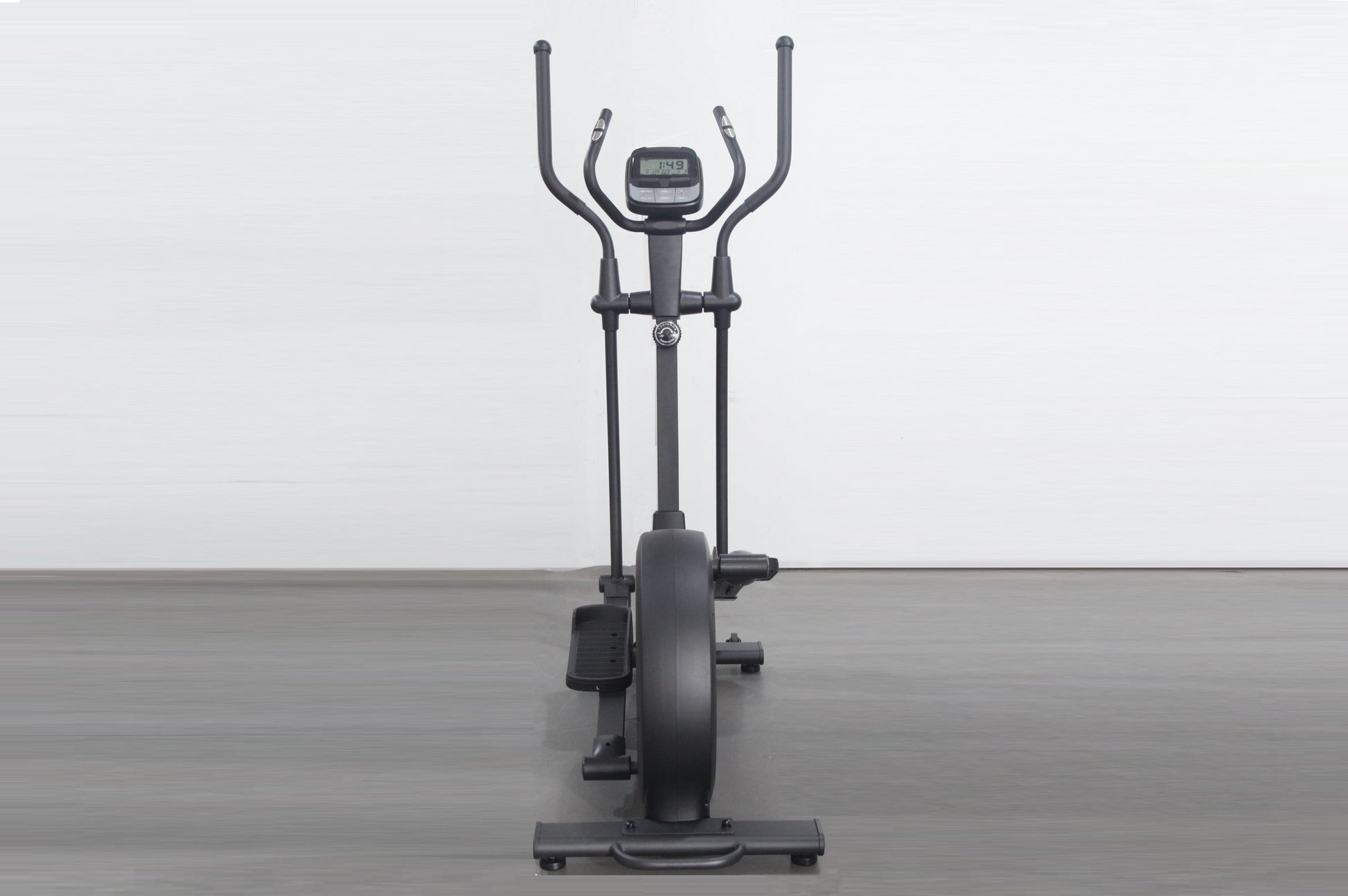 Black elliptical cross-trainer with dual handles, digital display console, and large flywheel, shown on gray floor against wh