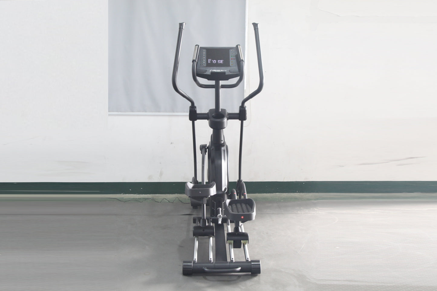 Black elliptical incline trainer with dual handles, digital display console, and foot pedals on white background