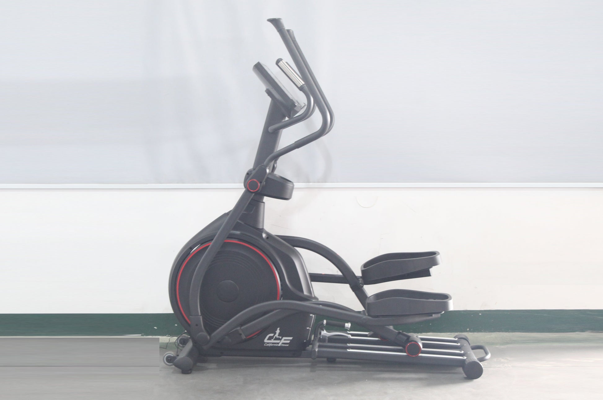 Black elliptical machine with red accent trim, dual handlebars, and padded seat on white background