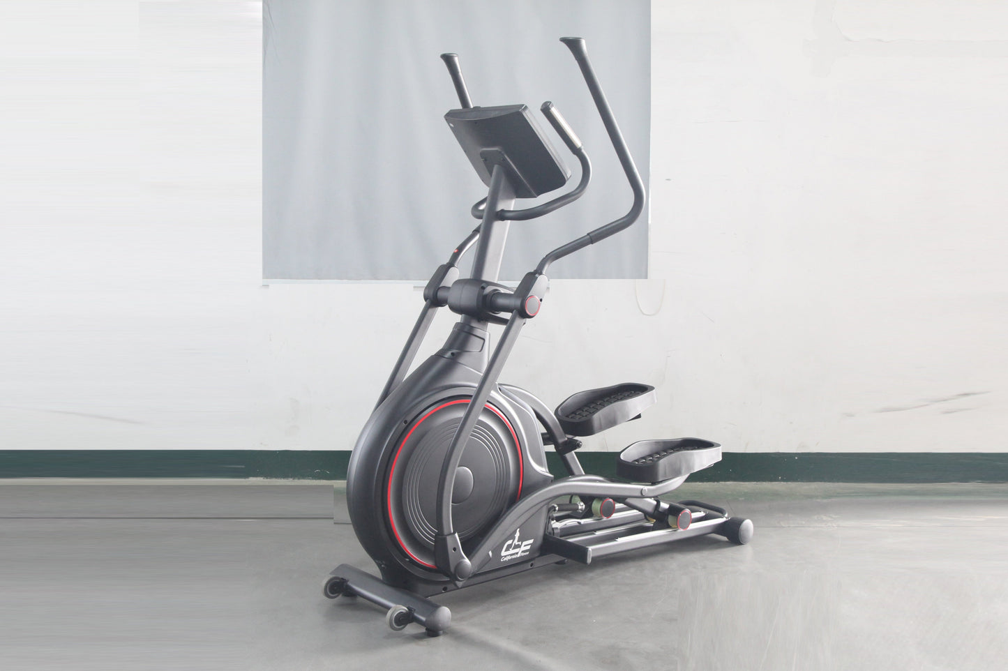 Black and gray stationary elliptical trainer with red accent trim and dual handle bars, displayed on concrete floor