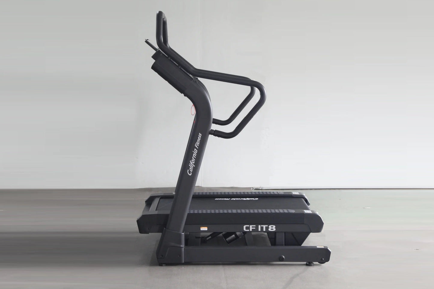 California Fitness IT8 black incline treadmill with curved running deck and dual handles, angled view on gray background