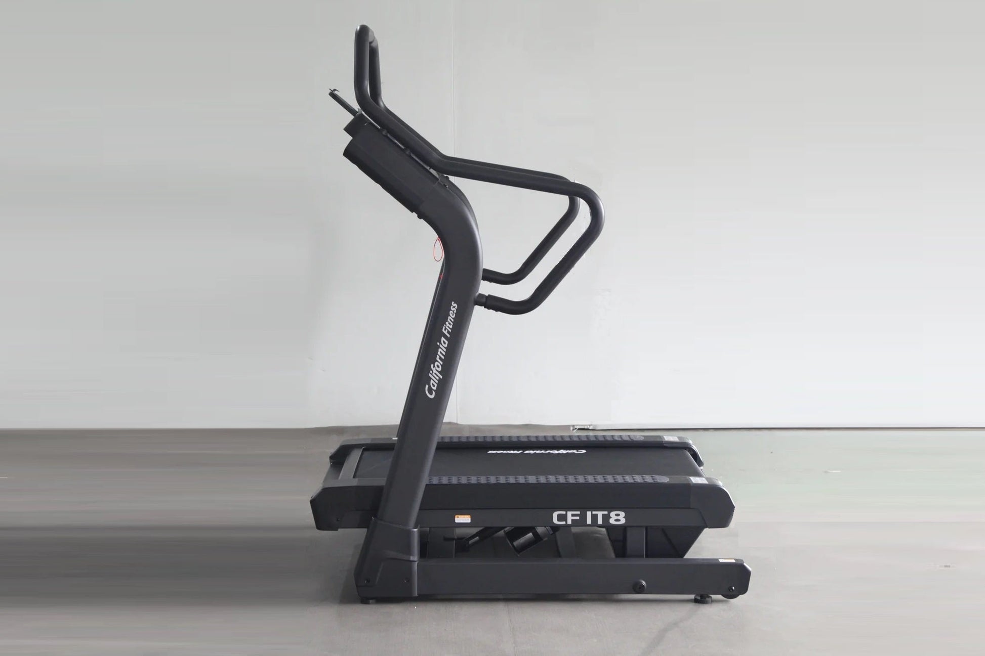 California Fitness IT8 black incline treadmill with curved running deck and dual handles, angled view on gray background