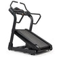 Black incline trainer treadmill with angled running deck, dual handrails, and digital display on white background