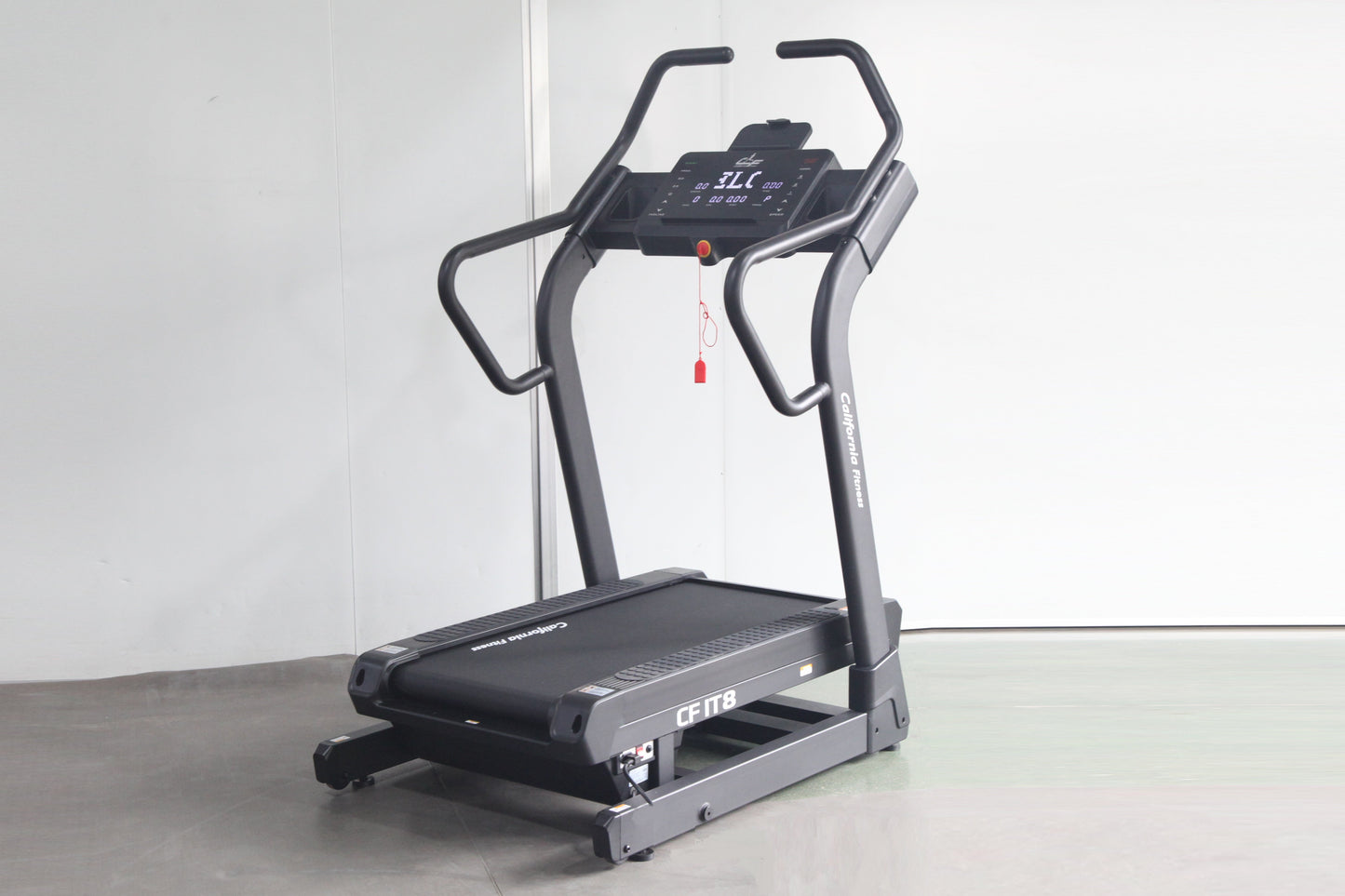 California Fitness IT8 incline trainer treadmill with black and gray frame, digital display console, and red safety clip on w