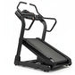 Black incline trainer treadmill with digital console, curved handles, and textured running deck on white background