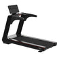 Black commercial treadmill with digital display console, cushioned running deck, and red accent trim on white background