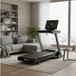 Black folding treadmill with digital display console in modern living room setting