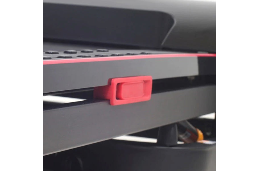 Bright red magnetic safety clip attached to gray folding treadmill console with black trim
