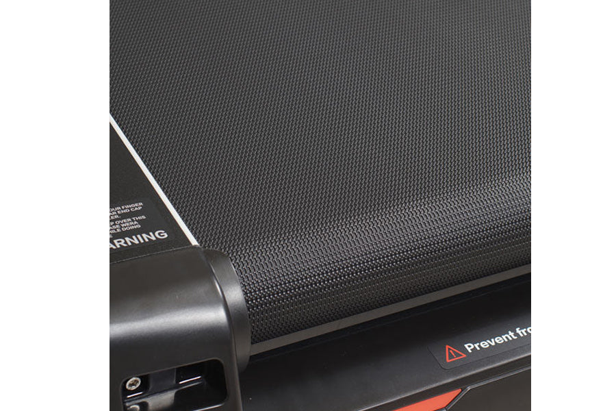 Gray textured treadmill belt and black frame with safety warning label and orange accent detail, flat lay view